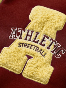 Gros plan de la broderie lettre A sur veste de baseball bordeaux de haute qualité