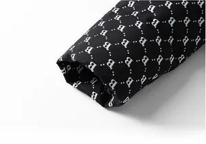 Close-up of black jacket cuff featuring stylish white letter B and star patterns