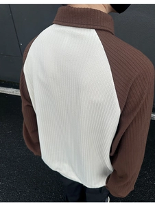 Close-up of the ribbed fabric texture and raglan sleeve contrast on this men's polo shirt