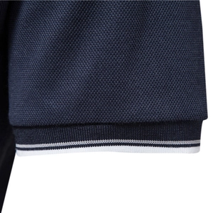 Men's navy cotton polo shirt featuring piqué fabric texture and white striped cuff detail