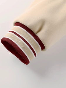Détail de la manche crème d'un blouson avec poignets élastiques rayés bordeaux et blancs
