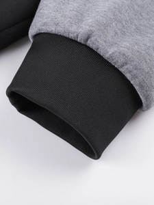 Macro shot of light gray knit sleeve with tight black ribbed elastic cuffs on hoodie