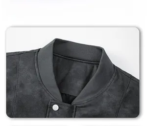 Detalle de chaqueta de ante gris oscuro con cuello acanalado y botón a presión metálico