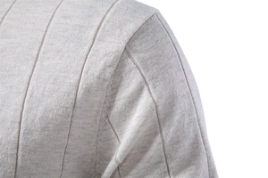 Vue macro de la couture d'épaule en tricot côtelé sur un pull gris à manches courtes