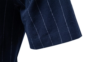 Gros plan sur le revers de manche d'une chemise rayée bleue en coton à texture naturelle