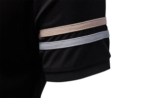 Detail of polo shirt cuff featuring black knit fabric with contrast herringbone stripes