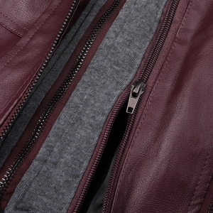 Détail macro d'une veste en cuir bordeaux montrant le zip et la doublure en tricot gris