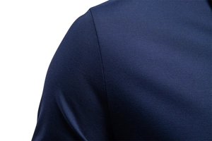 Detail of navy blue polo shirt showing premium jacquard texture and reinforced shoulder seams