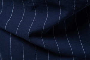 Gros plan d'un tissu en coton bleu marine de qualité avec fines rayures verticales blanches