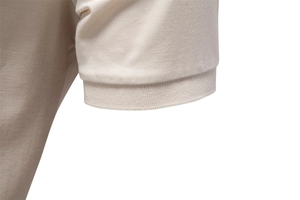 Close-up of beige pique cotton polo shirt sleeve with ribbed knit cuff detail