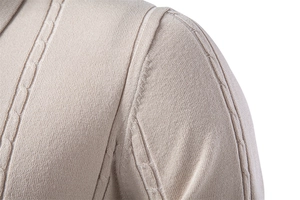 Detail showing cable knit texture and premium stitching on beige polo shirt shoulder