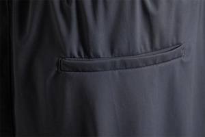 Détail des coutures de poche sur un short de sport gris foncé à haute élasticité