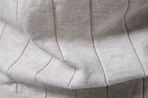 Détail macro du tricot de coton gris clair montrant une texture côtelée verticale