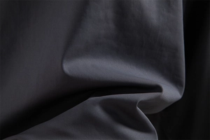 Gros plan du tissu gris anthracite hautement élastique et lisse pour shorts de sport d'été