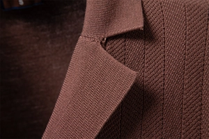 Detailed macro view of brown waffle knit fabric texture and shoulder seams on a polo shirt