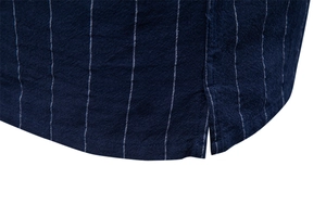 Détail macro d'une chemise en coton à rayures bleu marine avec fente latérale à l'ourlet