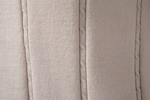 Macro shot of beige cable knit polo shirt fabric showing textured vertical stripes