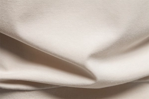 Macro shot of light beige knit fabric texture showing breathable pique mesh structure