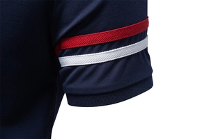 Macro detail of navy polo shirt sleeve with red and white herringbone stripe trim