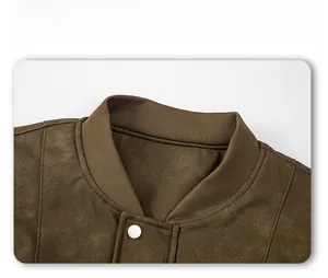 Detalle de la chaqueta de ante marrón con cuello alto y cierre de botón a presión metálico blanco