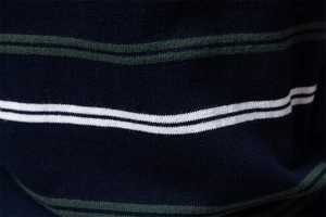 Detailed close-up of navy blue cotton knit fabric with white and green horizontal stripes