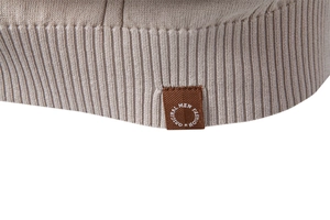 Detail of beige knit polo shirt showing ribbed hem and original fashion woven label