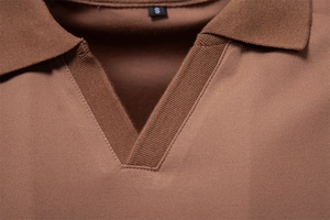 Detailed macro view of brown Tencel polo shirt collar with seamless V-neck stitching
