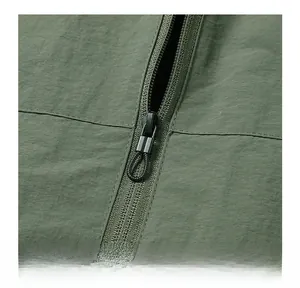 Detail of army green bomber jacket with black metal zipper and textured fabric finish