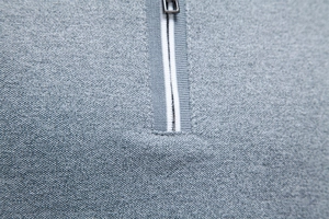 Detail of half-zip polo shirt showing grey knit texture and striped ribbed placket
