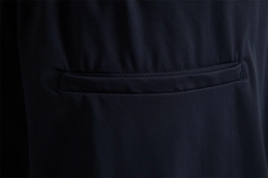 Gros plan sur le tissu élastique et les coutures de précision de la poche du short