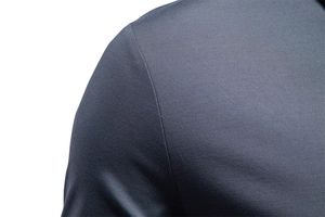 Macro view of seamless shoulder stitching on a high-quality navy blue jacquard polo shirt