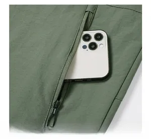Detail view of olive green flight jacket pocket showing smartphone storage capacity