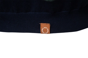Detail of navy knit t-shirt hem featuring ribbed edges and a brown fashion woven label