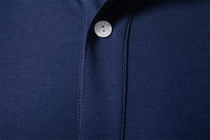 Detail shot of navy blue polo shirt collar featuring premium pique fabric and white buttons