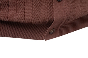 Close-up of brown knit Polo shirt featuring ribbed hem and premium button detail