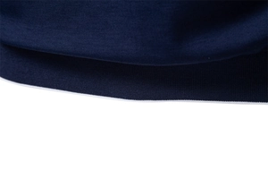 Macro shot of navy blue Tencel knit polo fabric featuring white contrast rib details