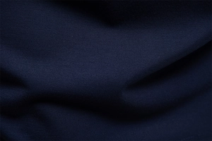 Macro shot of navy blue polo shirt fabric showing fine mesh texture and soft drape