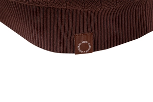 Macro shot of dark brown waffle knit fabric with ribbed hem and woven fashion label