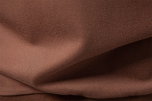 Macro texture view of coffee brown knit polo shirt fabric with smooth tencel fiber detail