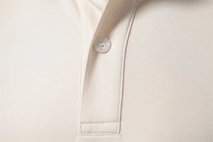 Macro detail of ivory Tencel Polo shirt collar showing fine knit texture and button