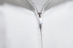 Detail of silver metal zipper and twill texture on white business polo shirt