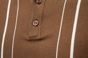 Détail macro du polo en maille marron avec rayures verticales blanches et col à boutons