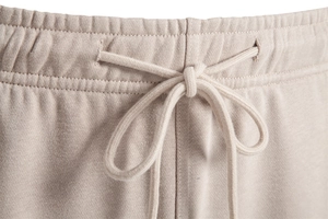 Détail macro de la taille élastique et du cordon de serrage du pantalon beige
