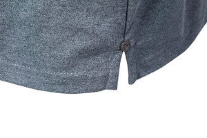Detail of dark grey polo shirt side slit with a geometric engraved metal rivet