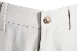 Detailed close-up of men's casual trousers featuring twill fabric and amber resin button