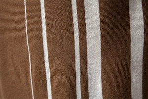 Gros plan sur le tissu en maille rayée verticale marron et blanc d'un polo pour homme