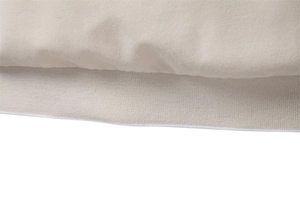 Macro shot of the elastic ribbed hem and sleeve detail on a beige business polo shirt