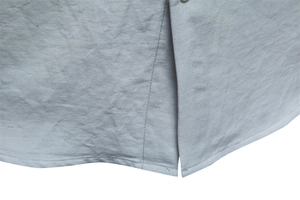 Detail of light gray shirt hem with high-quality linen texture and side slit design