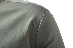 Gros plan des coutures d'épaule d'un t-shirt en coton vert olive aux finitions de qualité