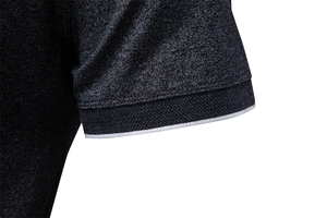 Detailed close-up of grey polo shirt sleeve with ribbed cuffs and white contrast tipping